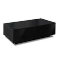 Black L-shaped coffee table styled in a living room with decorative items on top