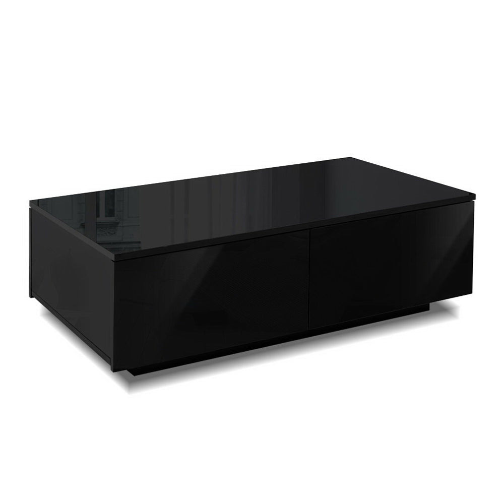 Black L-shaped coffee table styled in a living room with decorative items on top