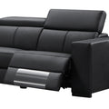 Black leather recliner sofa end seat close-up with footrest extended and headrest raised at angle