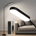 Black LED gooseneck floor lamp with lit oval head beside grey sofa, shown with remote and inline dimmer in living room