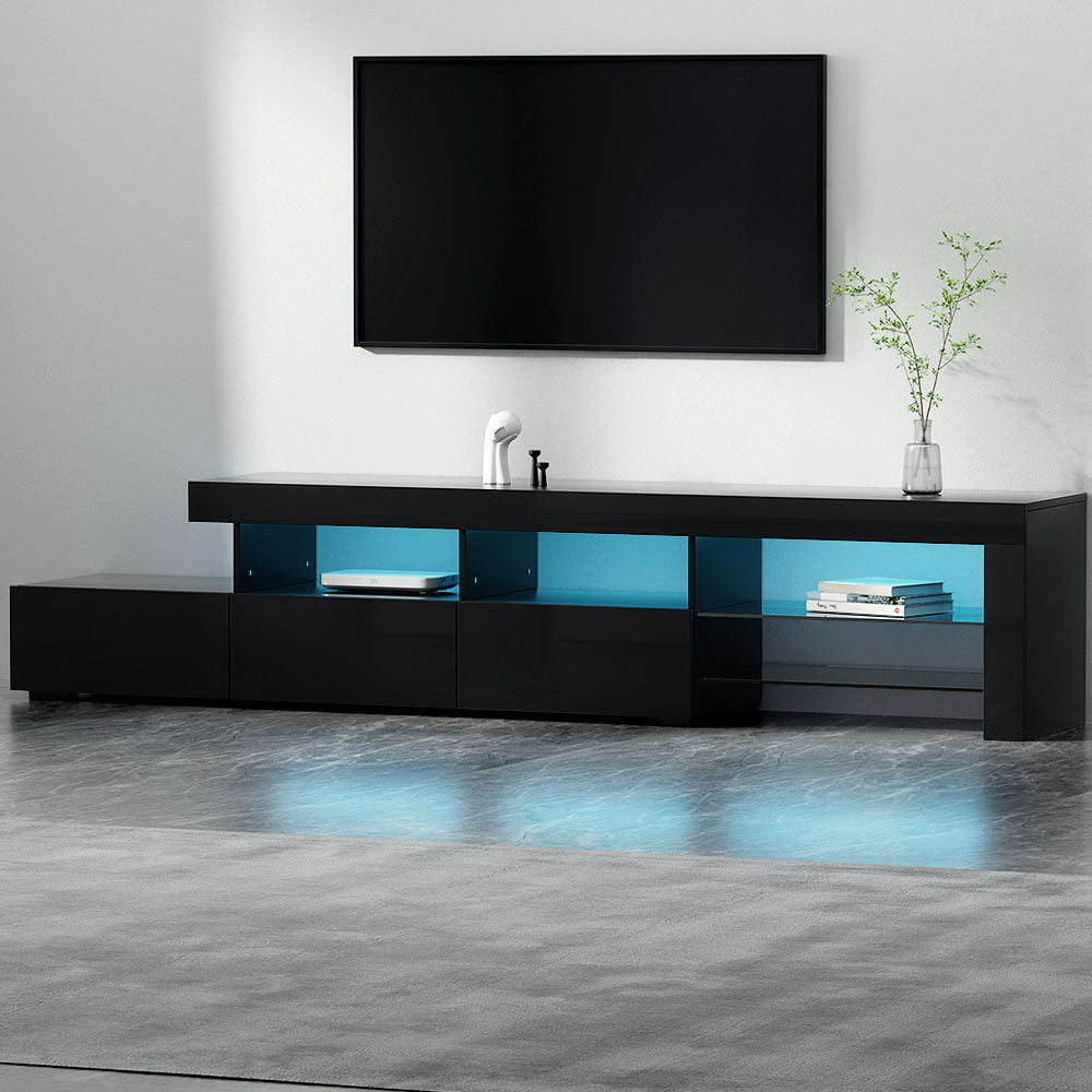 Black glossy 215cm LED TV unit in living room with blue LED lighting in open shelves below wall-mounted TV