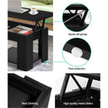 Black lift-top coffee table in living room with top raised and items placed inside storage