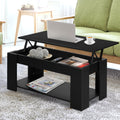 Black lift-top coffee table styled with books and a cup in a modern living room setting