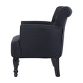 Dark charcoal linen armchair side view showing rolled curved back, button tufting, and turned black wooden legs