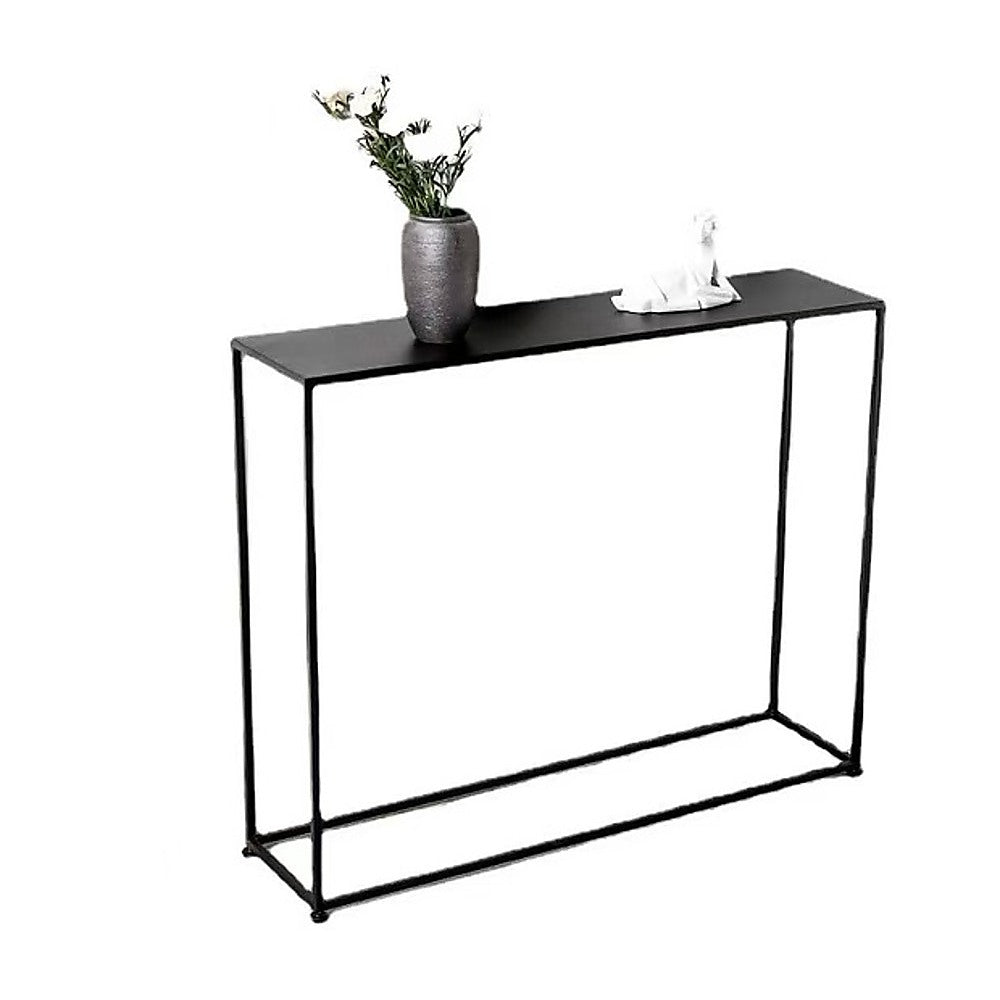Slim black metal console table with grey vase holding flowers and small white figurine on top, white background