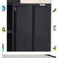 Close-up of black metal locker cabinet door open showing spring hinge mechanism and interior shelf