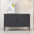 Charcoal black two-door metal sideboard cabinet with louvre vents on grey floor, abstract art print on top