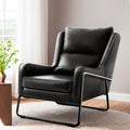 Black PU leather wingback armchair with metal sled frame on circular rug, lifestyle shot with sheer curtains and plant beside