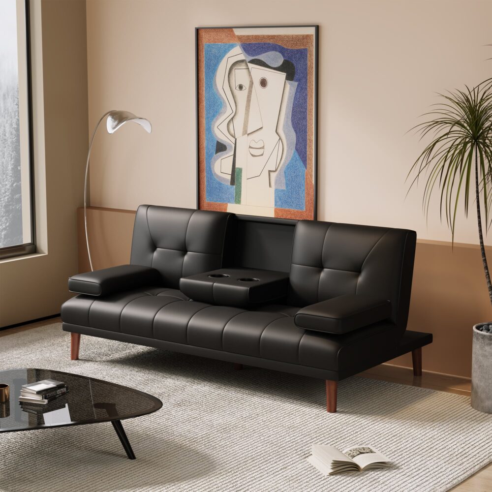Black PU leather sofa bed with centre armrest down showing two cup holders in room with palm plant