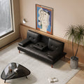 Black PU leather sofa bed with cup holders open in modern living room with abstract artwork