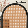 Black arched rattan room divider curved edge close-up in lifestyle with red berry branch vase and sideboard