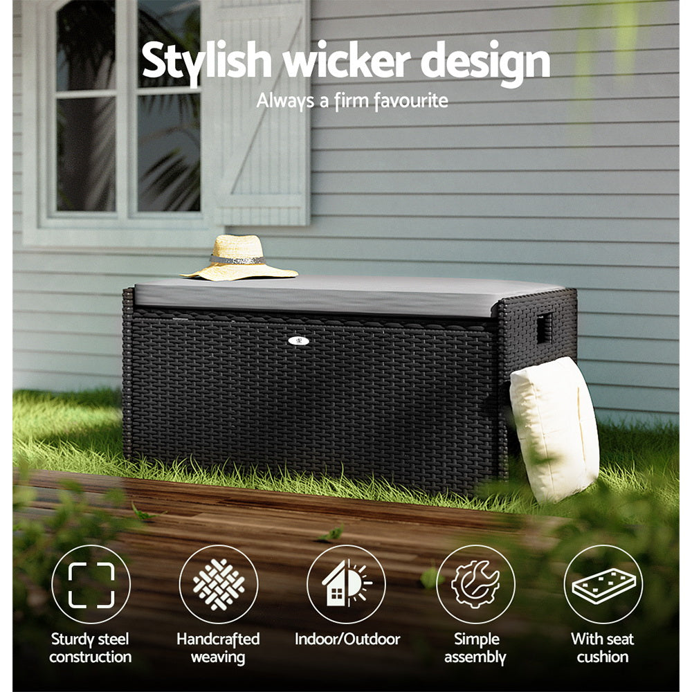Black rattan storage bench outdoors with straw hat and throw; icons: sturdy steel, handcrafted, indoor/outdoor, seat cushion