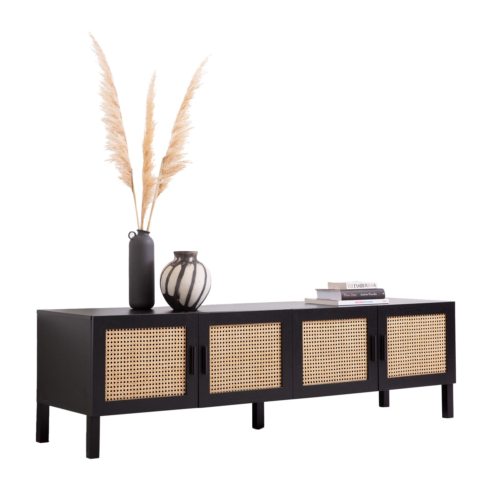 Black rattan TV unit angle view on white pampas grass tall dark vase striped vase and stacked fashion books