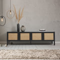 Black rattan TV unit lifestyle in grey concrete room with pampas grass vase dark vessels books and pendant lights