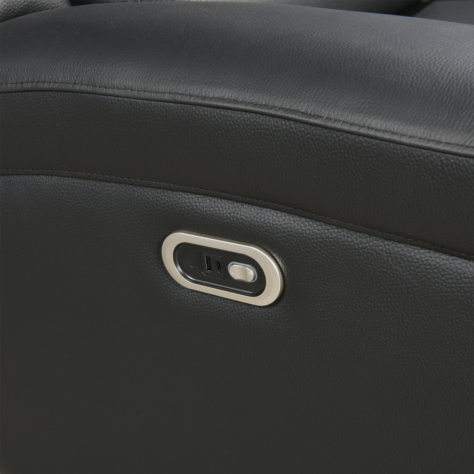 Close-up of dark leather recliner side panel with built-in USB and power outlet