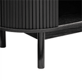 Close-up of black reeded sideboard curved base rail, rounded end reeded panel and two tapered legs