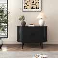 Black reeded sideboard front view in room with abstract wall art, table lamp and flower vase on top, indoor plant on left