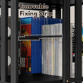 Close-up of black rotating media tower shelf loaded with game cases, dashed lines highlighting removable fixing strip