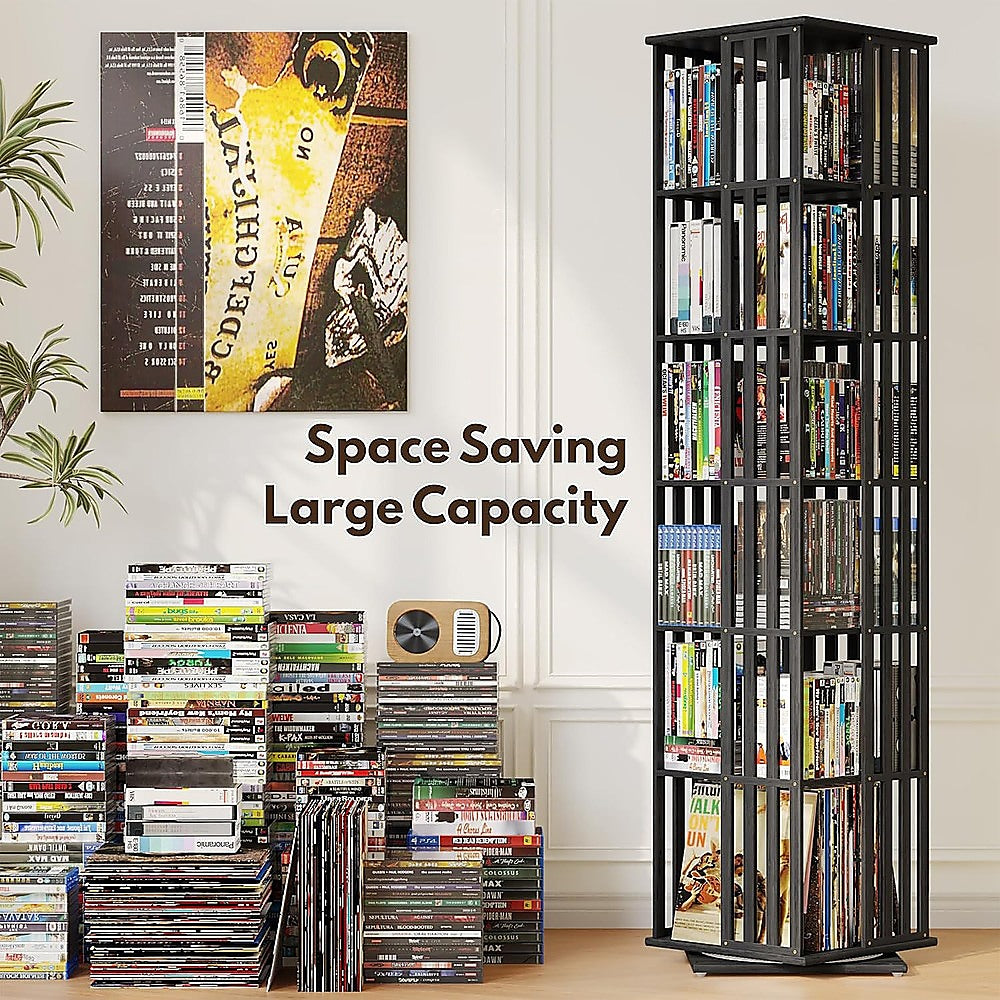Black rotating media tower loaded with DVDs and CDs beside stacked disc pile, text overlay reads Space Saving Large Capacity