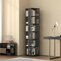 Black rotating tower bookshelf with 6 tiers loaded with books in study setting, turntable and desk lamp alongside