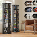 Two black rotating tower bookshelves filled with DVDs and books in music room with vinyl records on wall and leather armchair