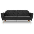 Black velvet tufted sofa bed with angled arms, button-tufted back and tapered walnut legs, front view