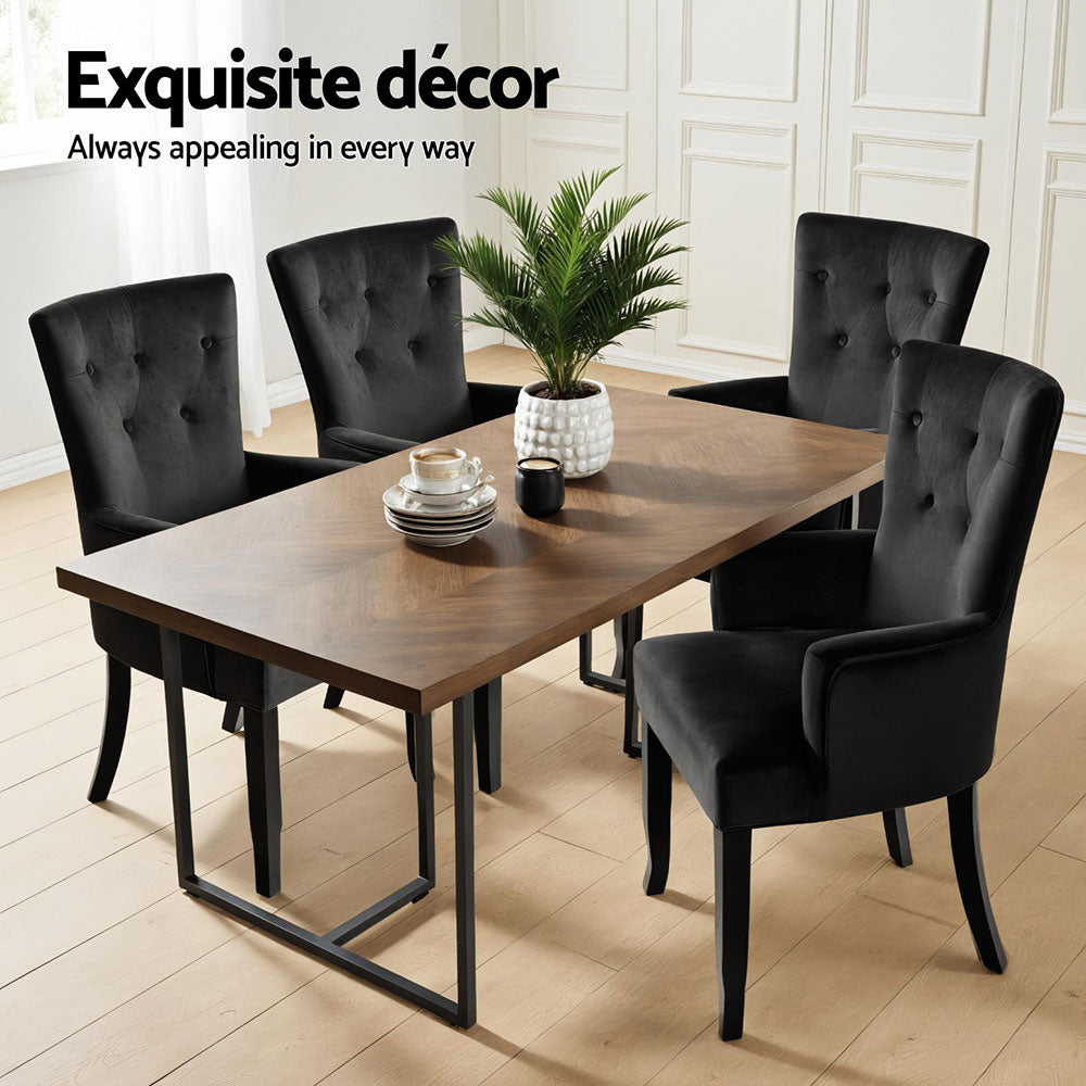 Four black velvet wingback dining chairs around herringbone wood table, "Exquisite decor" overlay, white panelled room