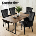 Four black velvet wingback dining chairs around herringbone wood table in white panelled room with plant and coffee cups