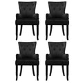 Set of four black velvet button-tufted wingback dining chairs, front view in two-by-two grid on white background
