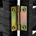 Black woven paper rope room divider gold two-way hinge close-up showing brass screws and pivot on black woven frame