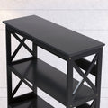 Close-up top-angle view of black X-frame bookshelf showing flat top surface, X-panels and upper shelves against concrete wall