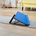 Blue adjustable calf stretching board placed on grey yoga mat on wooden floor in home lifestyle setting