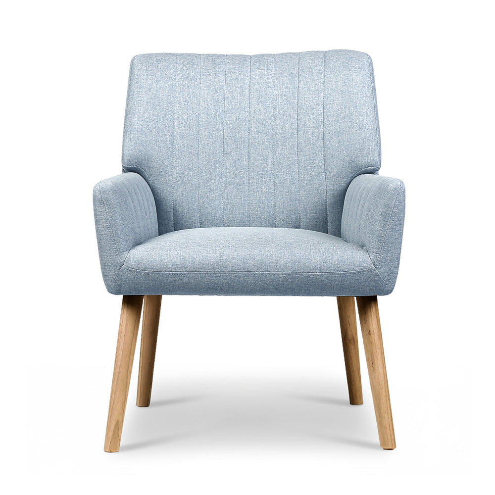 Light blue grey fabric armchair with channel-stitched backrest and natural wood legs, direct front view on white background