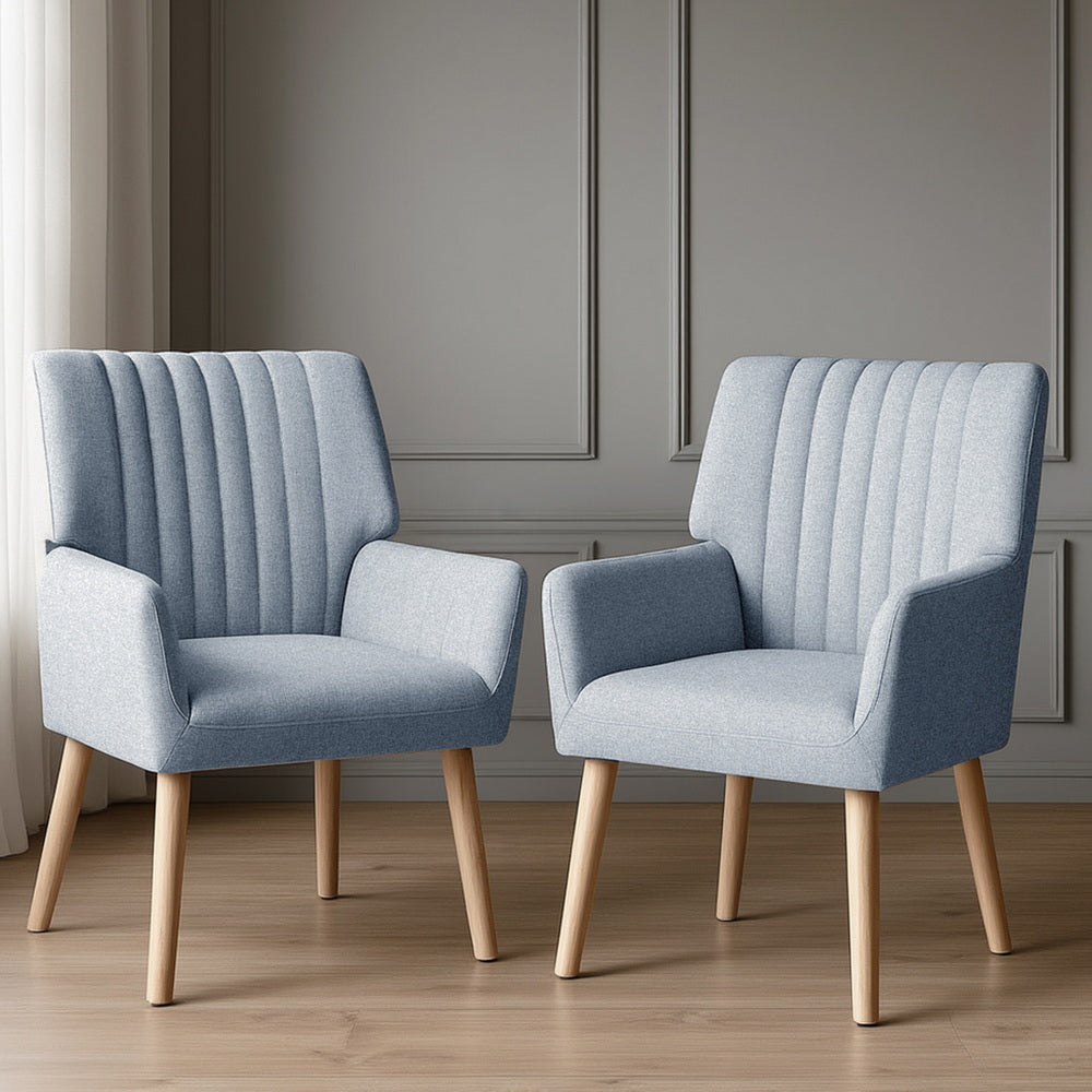 Pair of light blue grey channel-stitched fabric armchairs on timber floor, grey panelled wall background