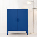 Navy blue metal locker against white wall in living room, D-ring handles, louvre vents at base, chrome floor lamp beside