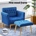 Blue velvet armchair and ottoman in room with blue rug, 