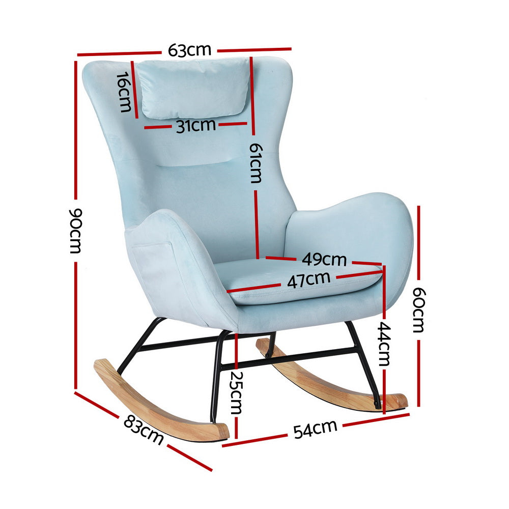Light blue velvet wingback rocking chair with headrest pillow and wood runners, lifestyle shot with wicker table and plant