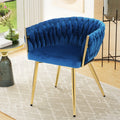 Blue velvet accent chair with woven braided backrest and gold metal legs in living room with round side table