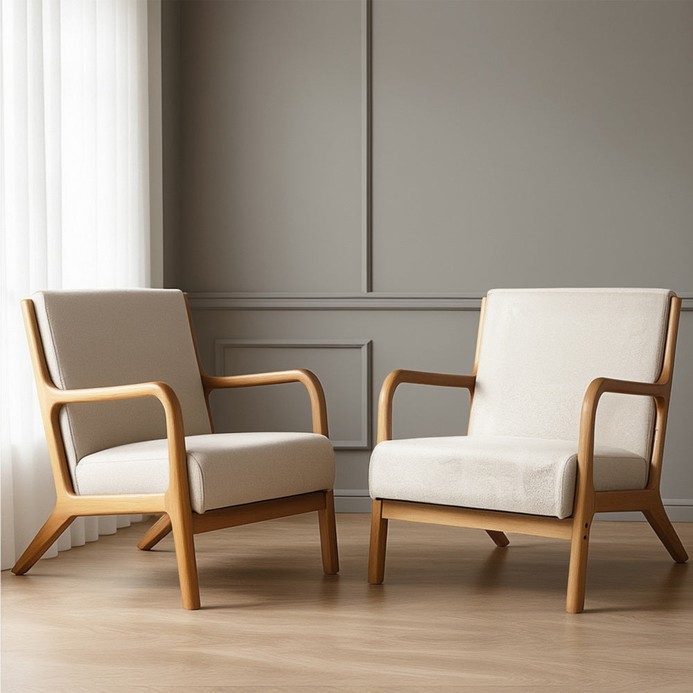 Pair of cream boucle armchairs with curved natural wood frames side by side in grey panelled lifestyle room