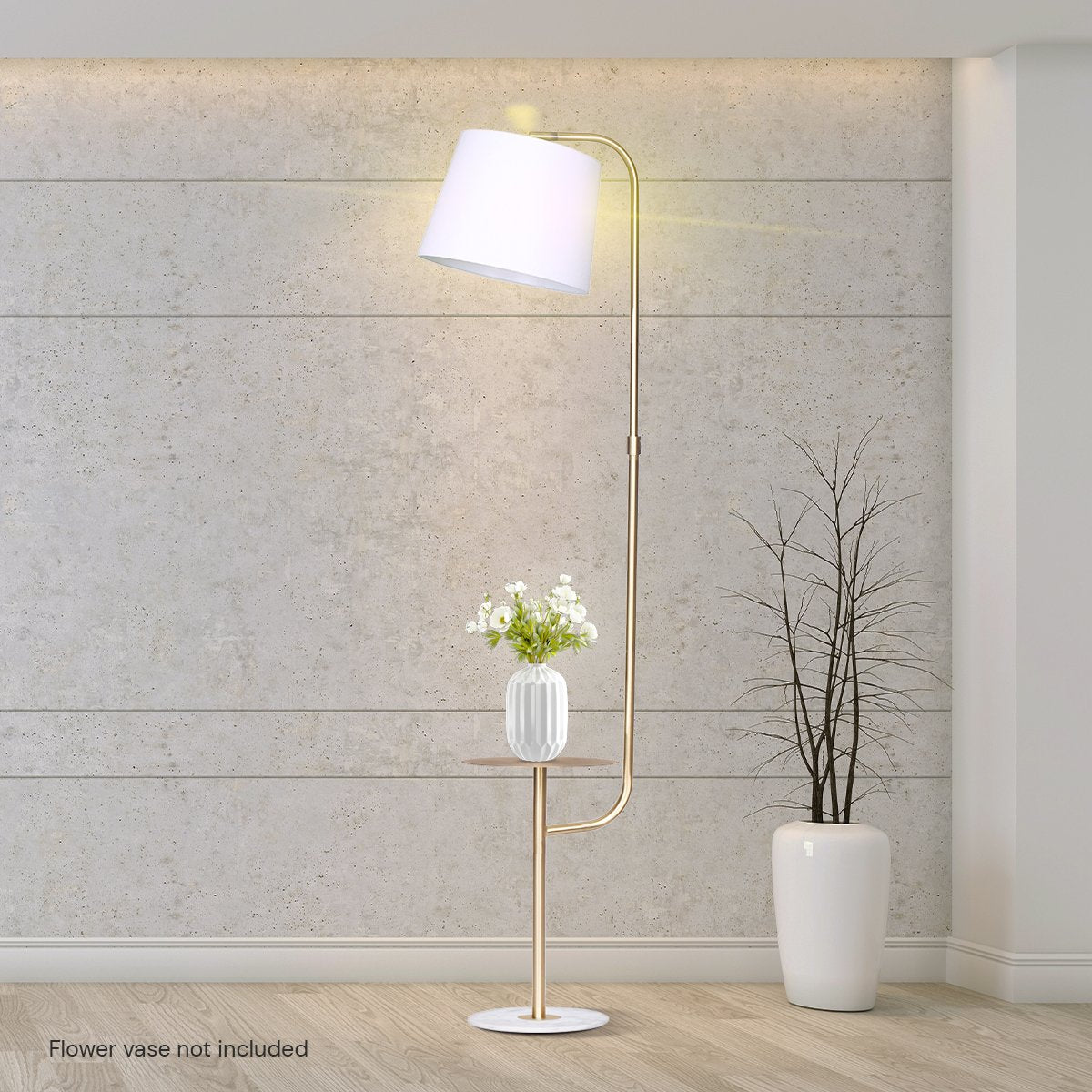 Arc floor lamp with side table lit against concrete wall, white flower vase on side table, bare branch vase beside it