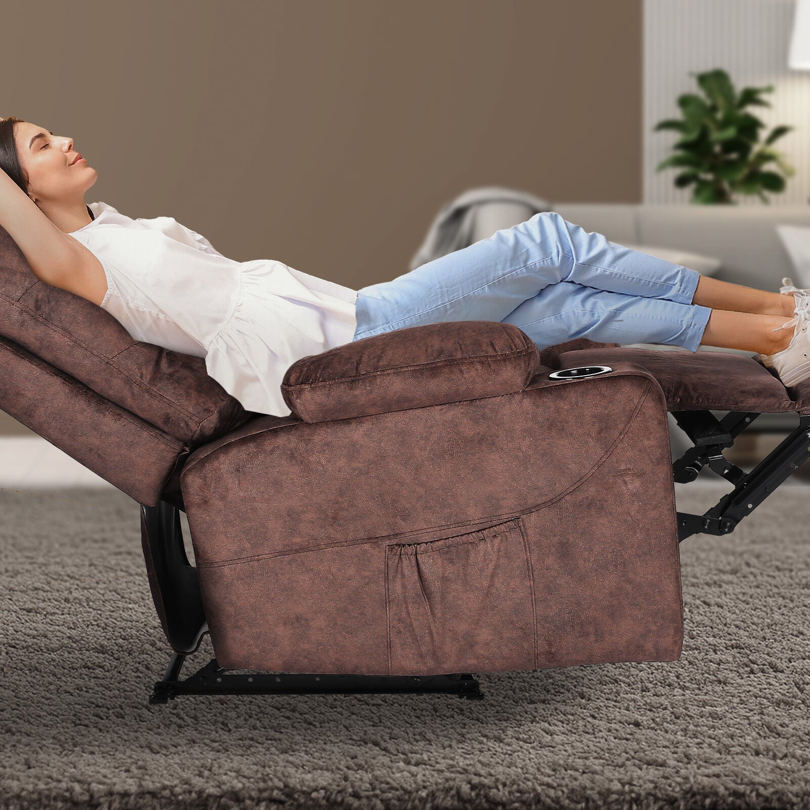 Woman lying fully reclined in brown fabric tufted recliner with footrest extended and cup holder, living room with grey rug