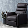 Dark brown PU leather recliner chair with segmented padded back beside rubber plant, grey textured wall background