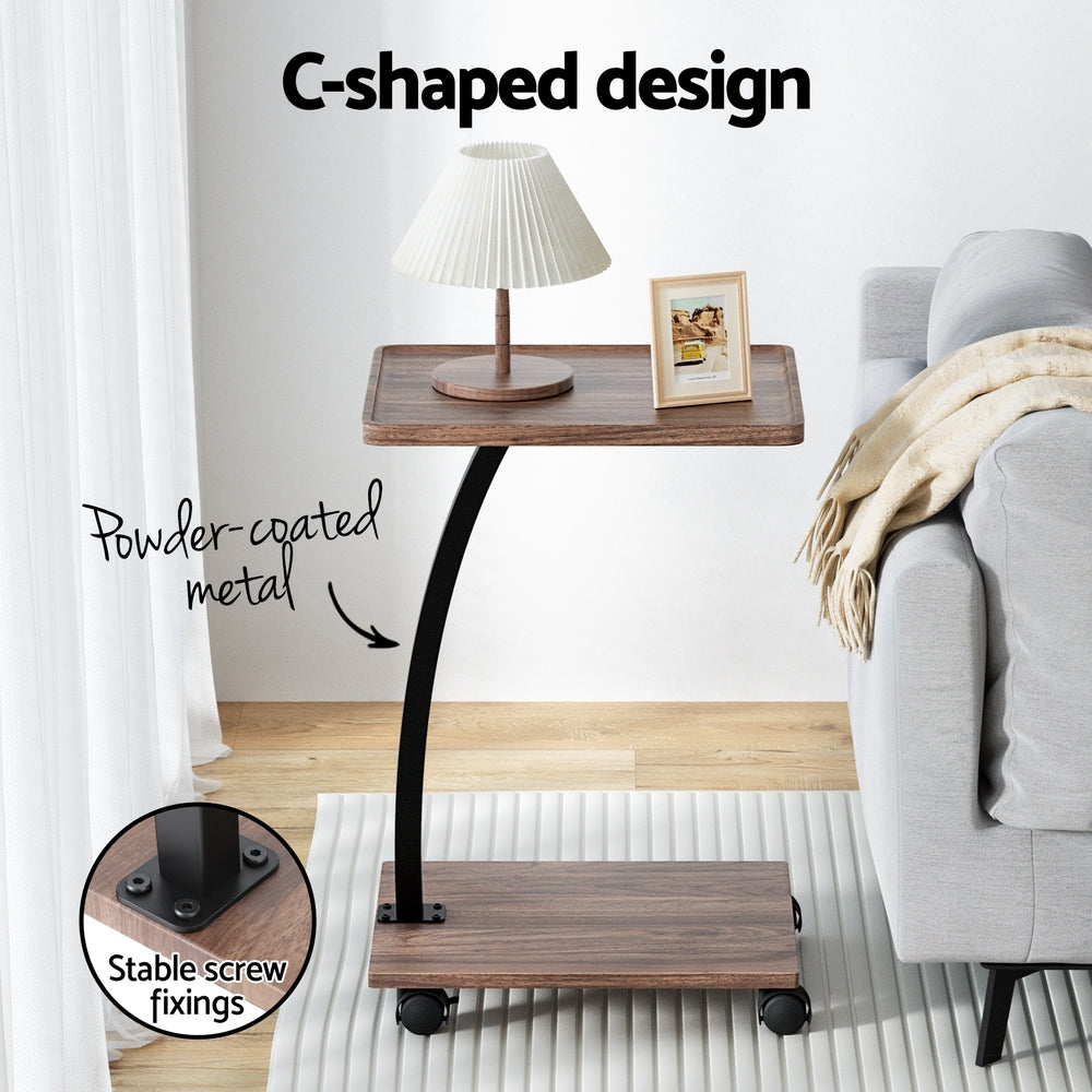 C-shaped side table features: powder-coated metal post and stable screw fixings, lamp on top, grey sofa behind