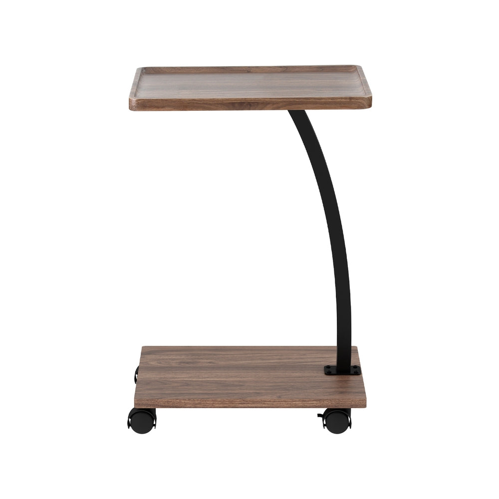C-shaped mobile side table front view on white background, walnut tray top with raised edges, curved black post, four castors