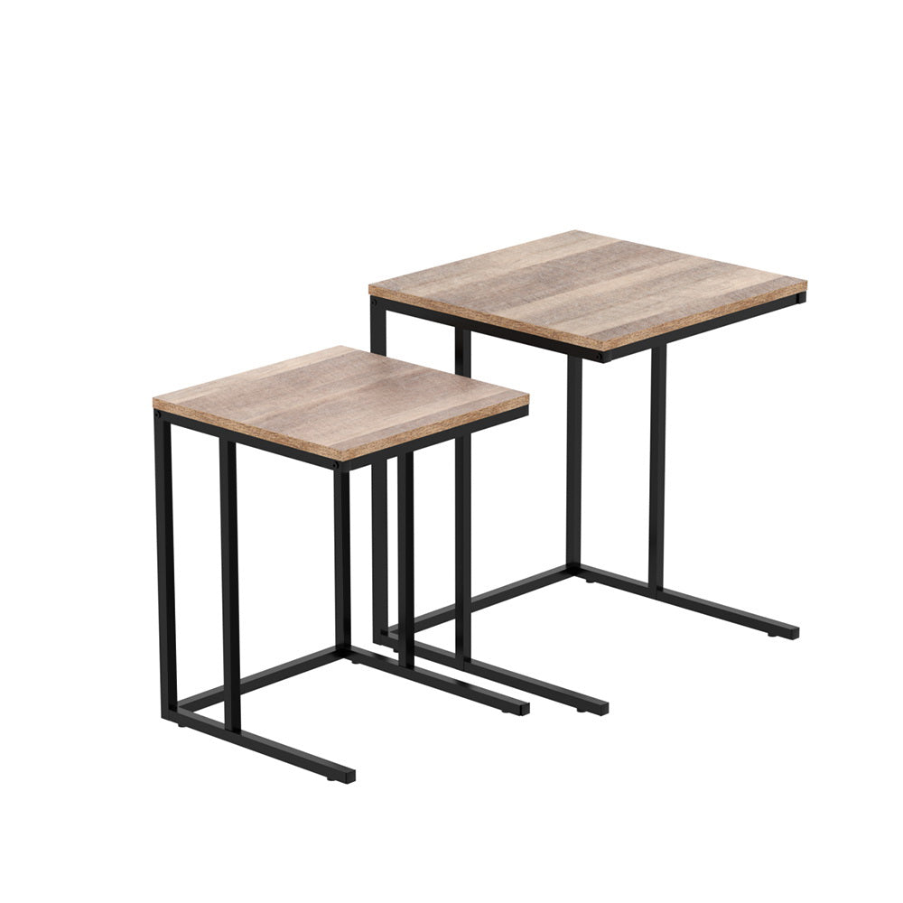 Two C-shaped nesting side tables with wood-grain particleboard tops and black metal frames, white background, different