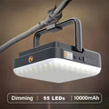 Square camping light hanging from tree branch by metal handle, white LED panel below, text Dimming 95 LEDs 10000mAh