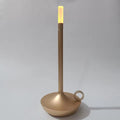 Champagne gold candle-style LED table lamp with ring handle on round base, warm amber glow at top, grey background