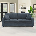 Charcoal blue 3-seater sofa with two scatter cushions in living room with large windows and plant