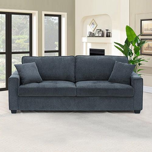 Charcoal blue 3-seater sofa with two scatter cushions in living room with large windows and plant