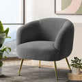 Charcoal grey boucle tub chair with rounded barrel back and gold metal tapered legs in living room near window